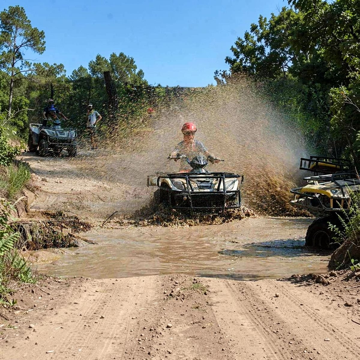 Quad splashing through mud on off-road track