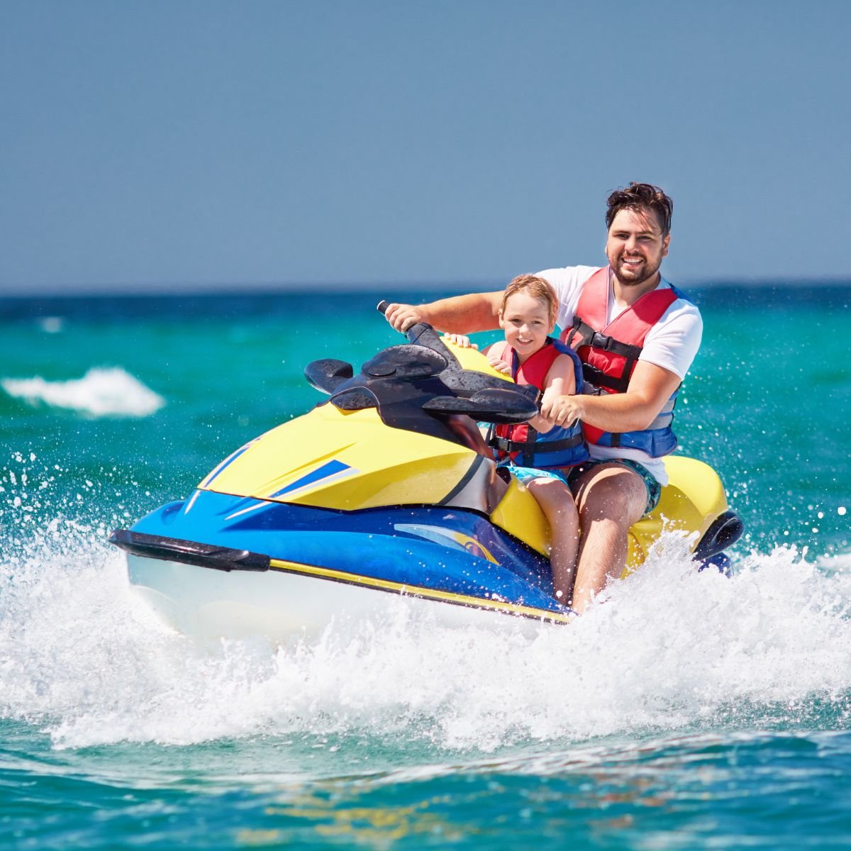 Father and child riding a jet ski