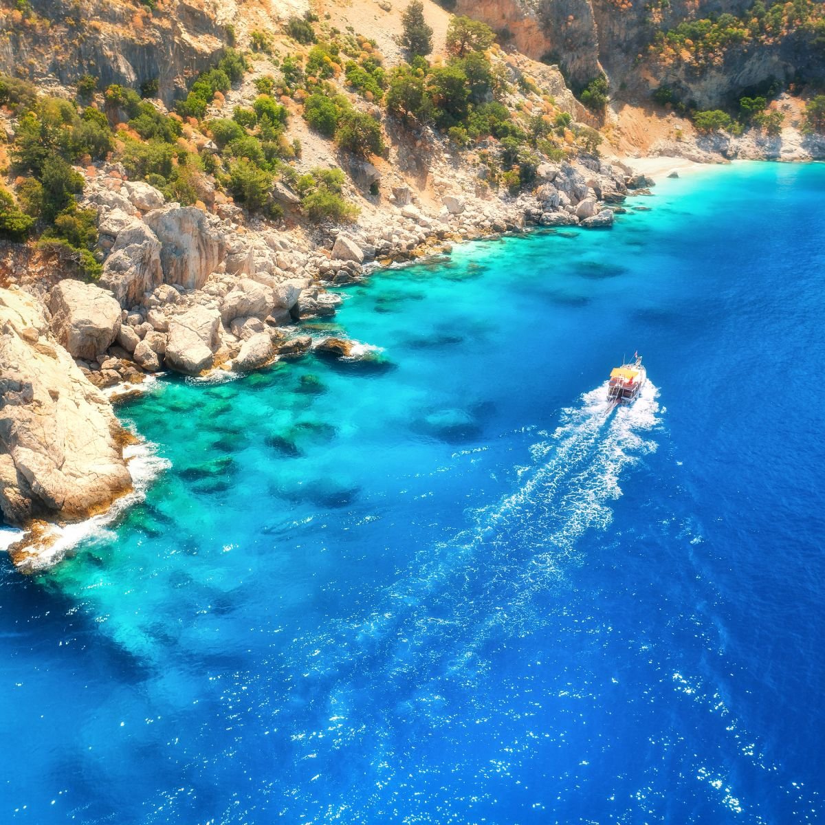 Aerial view of boat cruising along coast
