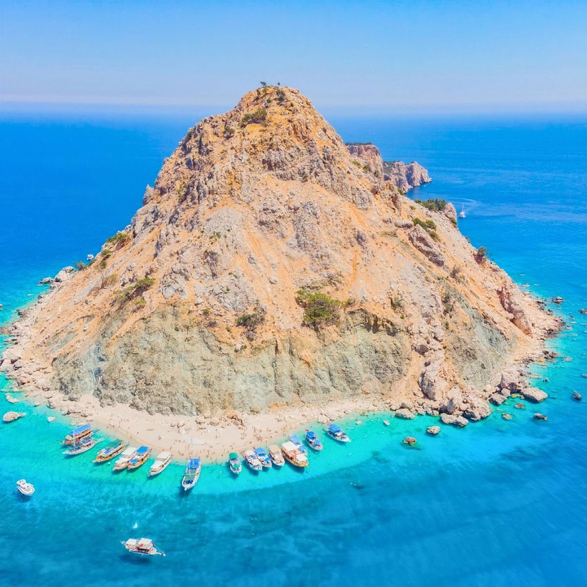 Suluada island with turquoise water and boats