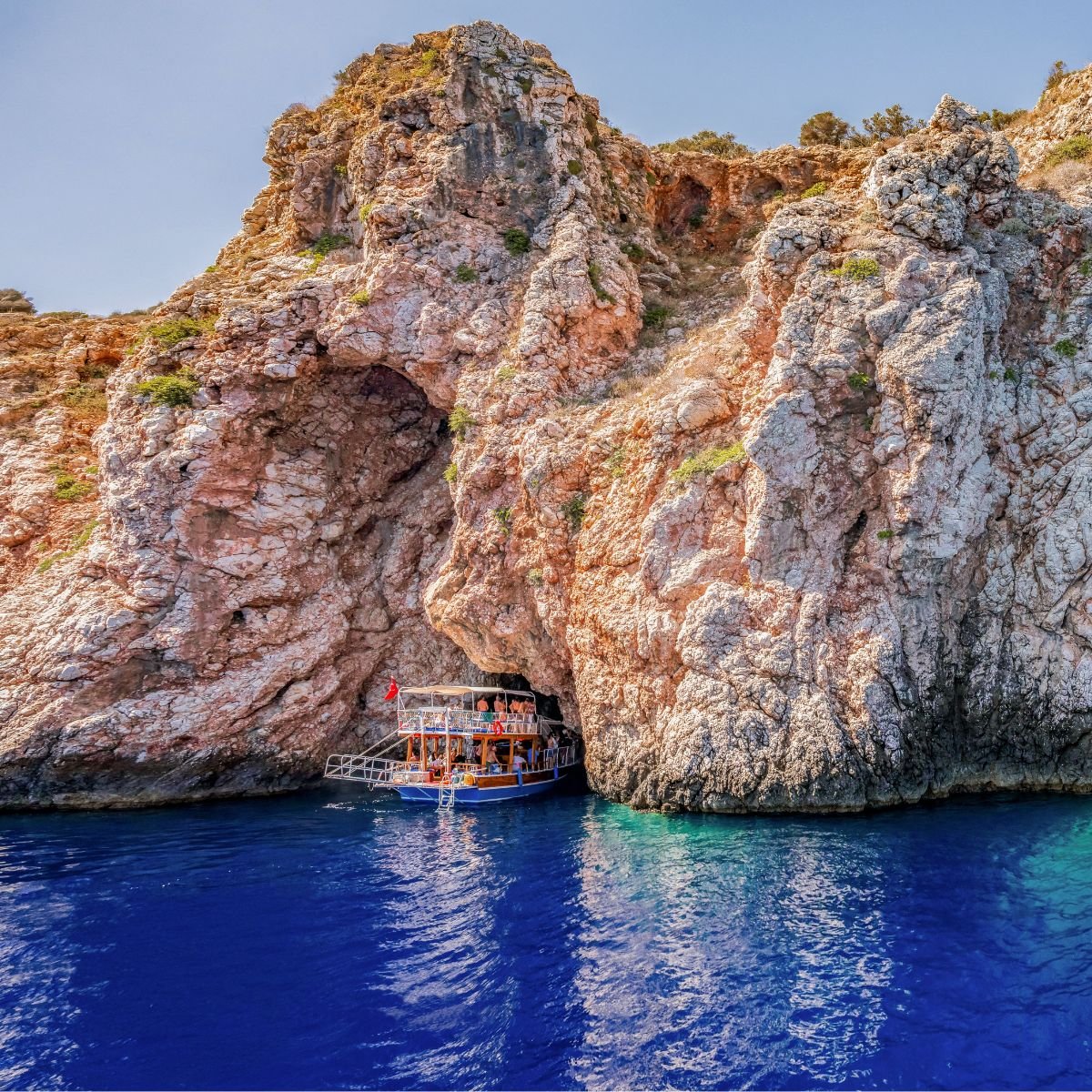 Traditional gulet at rocky cave entrance