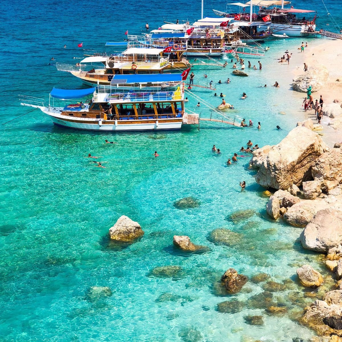 Boats and swimmers at Suluada beach