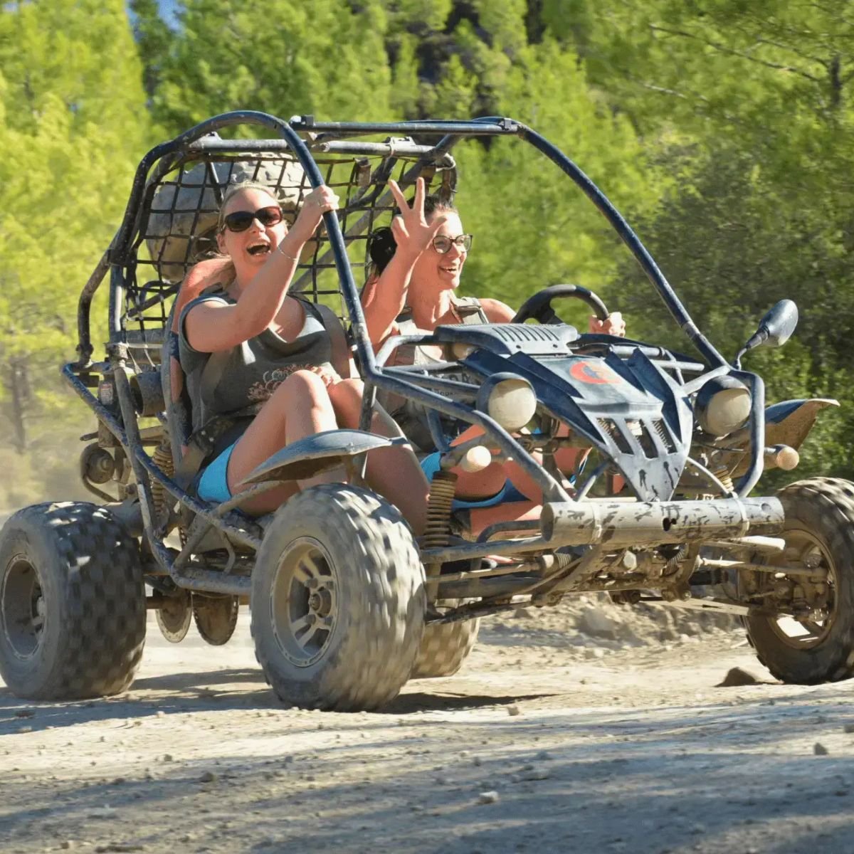 Two friends cheering in a buggy on forest trail