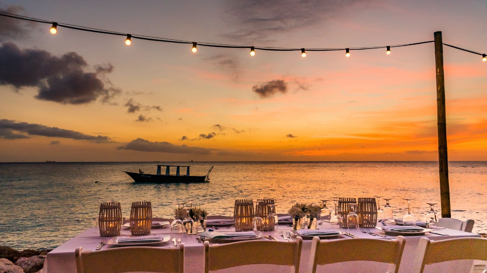 Seaside dinner table at sunset with string lights — Turkish Riviera restaurant