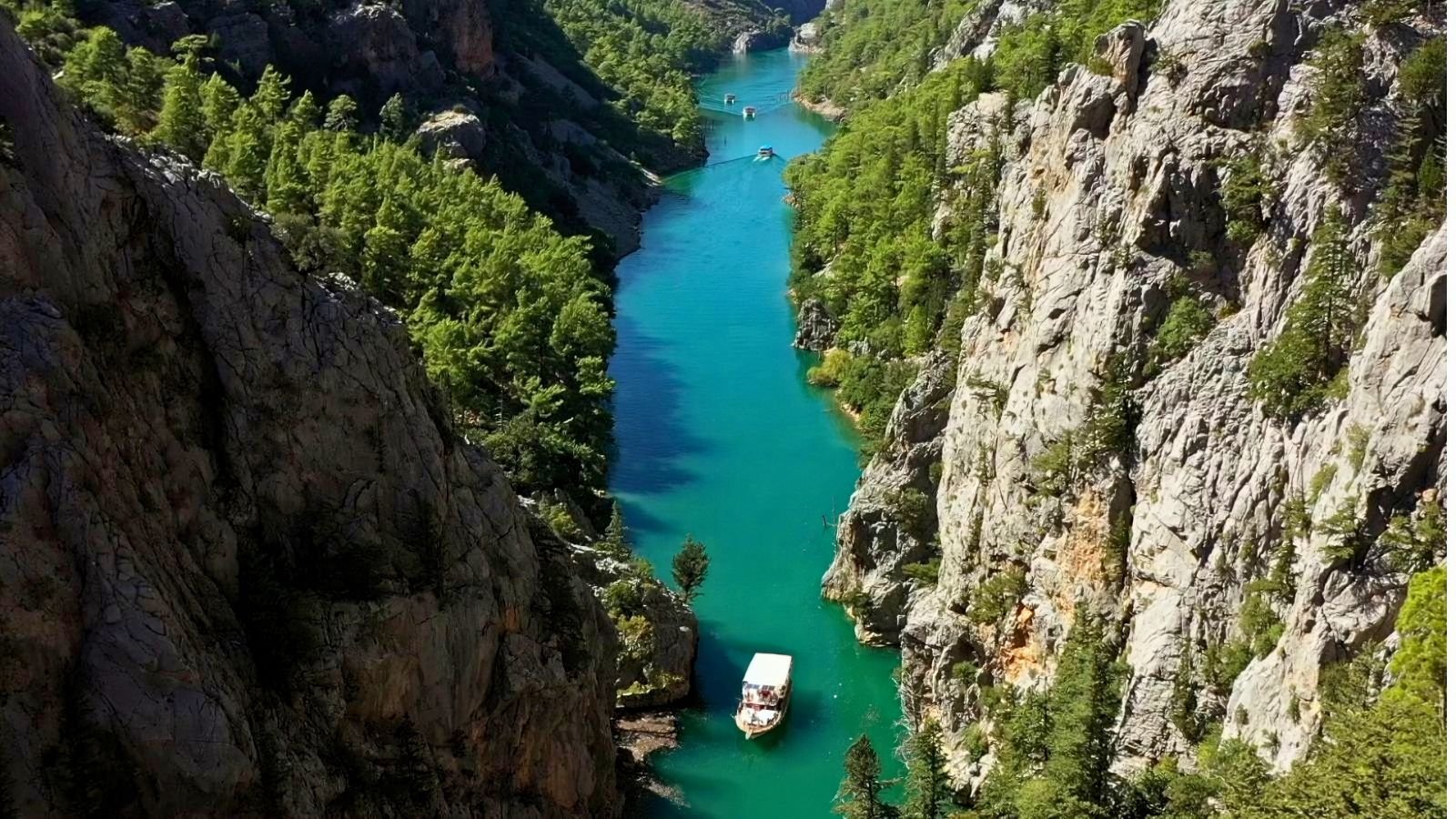 Green Canyon boat tour through emerald waters and cliffs